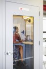 Жінка в офісі телефонна будка використання ноутбука для відео-дзвінок — стокове фото