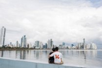 Vista posteriore della coppia seduta vicino all'acqua, Panama City, Panama, Panama — Foto stock
