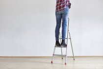 Человек, стоящий на лестнице — стоковое фото