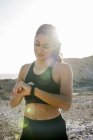 Молода жінка бігун перевірки smartwatch біля узбережжя, Лас-Пальмас, Канарські острови, Іспанія — стокове фото