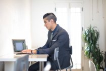 Junge Erwachsene Geschäftsmann Tippen auf Laptop am Schreibtisch — Stockfoto