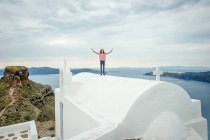 Ragazza in piedi sopra la chiesa, Santorini, Kikladhes, Grecia — Foto stock