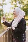 Молода жінка в хіджабі бере селфі на відкритому повітрі — стокове фото