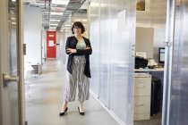 Портрет деловой женщины, стоящей в служебном коридоре — стоковое фото