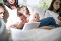 Сім'я грає з цифровим планшетом на дивані — стокове фото