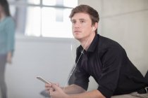 Молодий чоловік офісу мріє за столом прослуховування навушників — стокове фото