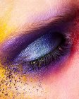 Primer plano del ojo de mujer con sombra de ojos de polvo de color - foto de stock