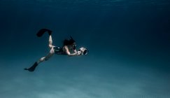 Unterwasseransicht einer Freitaucherin mit Unterwasserkamera, Bimini, Bahamas — Stockfoto