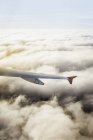 Airplane wing above clouds — Stock Photo