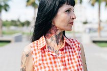 Зріла жіноча хіпстерка з татуйованою шиєю, крупним планом — стокове фото