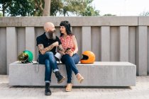 Tatuato maturo hipster coppia seduta su una panchina di cemento — Foto stock