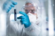 Labormitarbeiter untersucht Flüssigkeit im Reagenzglas — Stockfoto