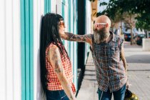 Mature hipster couple face to face on sidewalk — Stock Photo