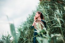Жінка біля довгої трави торкається волосся — стокове фото