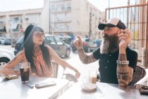 Mature hipster couple chatting at sidewalk cafe, Valencia, Spain — Stock Photo