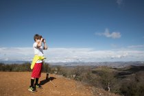 Garçon explorant avec caméra dans les collines, Mille Chênes, Californie, États-Unis — Photo de stock