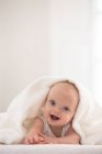 Portrait of cute baby boy wrapped in white towel — Stock Photo