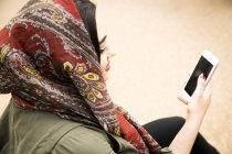 Blick über die Schulter einer Frau, die mit Smartphone Hijab trägt — Stockfoto