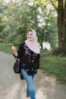 Young woman wearing in hijab walking on park — Stock Photo