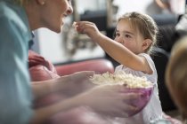 Девочка кормит мать попкорном — стоковое фото