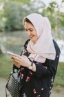 Jovem mulher vestindo no hijab olhando para o smartphone — Fotografia de Stock