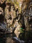 Серед дорослого туриста, який сидить на скелі і дивиться на ущелину Азул (Кайон - дель - Азул) поблизу Ель - Болсона (Патагонія, Аргентина). — стокове фото