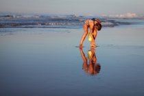 Chica en la playa recogiendo conchas marinas, North Myrtle Beach, Carolina del Sur, Estados Unidos, América del Norte - foto de stock