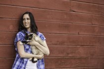 Портрет молодої жінки, що тримає кота, посміхається — стокове фото