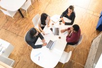 Overhead view of business team meeting at office table in office kitchen — Stock Photo