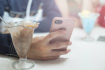 Close-up view of smartphone in hand of Young man sitting in diner — Stock Photo