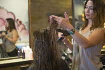 Жіночий перукар, що працює з клієнтом у салоні — стокове фото