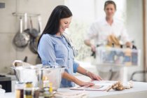 Husband and wife making preparations in kitchen — Stock Photo