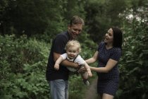 Coppia incinta oscillante bambino figlio sul sentiero — Foto stock