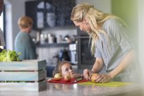 Mulher com filha preparando comida na cozinha — Fotografia de Stock