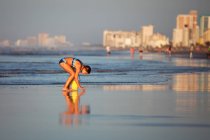 Chica en la playa recogiendo conchas marinas, North Myrtle Beach, Carolina del Sur, Estados Unidos, América del Norte - foto de stock