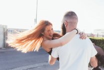Mann trägt lächelnde Frau im Arm — Stockfoto