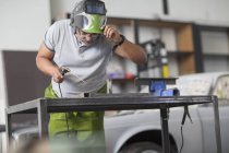 Сварщик за работой в мастерской по ремонту кузовов — стоковое фото