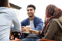 Friends enjoying coffee in outdoor cafe — Stock Photo