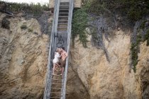 Romantic couple on stairs to beach, Malibu, California, US — Stock Photo