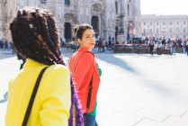 Mujeres turistas caminando fuera de Il Duomo, Milán, Italia - foto de stock