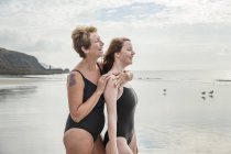 Vista lateral da mãe e da filha em pé na praia — Fotografia de Stock