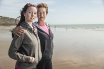 Мать и дочь смотрят в камеру на пляже — стоковое фото