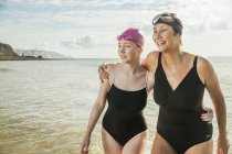 Mãe e filha em trajes de natação na praia — Fotografia de Stock