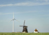 Une éolienne moderne et un moulin à vent traditionnel néerlandais sont réunis, Workum, Frise, Pays-Bas — Photo de stock
