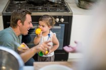 Father laughing at baby girl trying lemon — Stock Photo