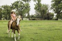 Young woman riding bareback on horse in ranch field, Bridger, Montana, USA — Stock Photo