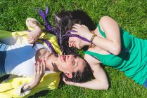 Дві жінки лежать на траві і сміються — стокове фото