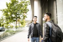 Двоє молодих чоловіків посміхаються на вулиці — стокове фото