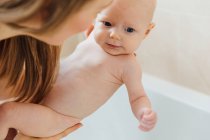 Vue d’angle élevé de mère bain bébé fille — Photo de stock