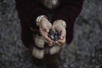 Petits cailloux de mer dans les mains de l'enfant — Photo de stock